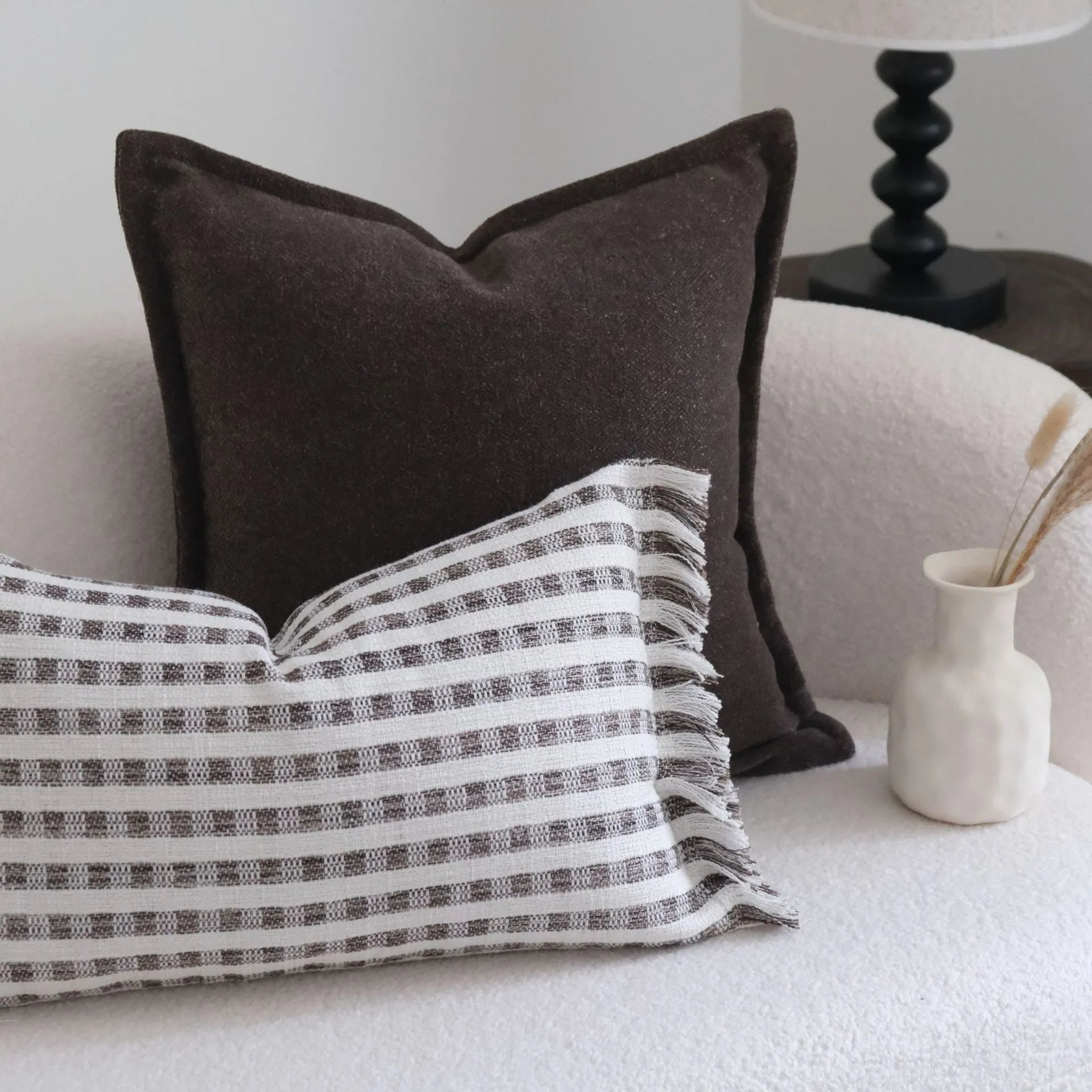 Coffee brown striped decorative cushion on a sofa in Chinese classical mid-century modern style.