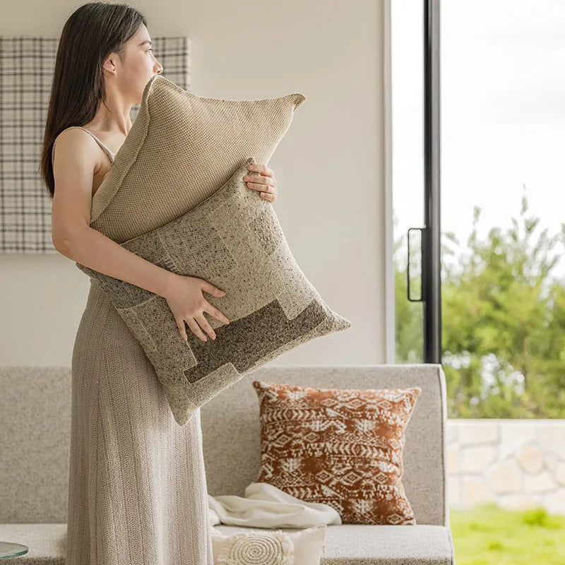 Solid colour decorative cushion on a sofa, showing its square shape and pp cotton filling.