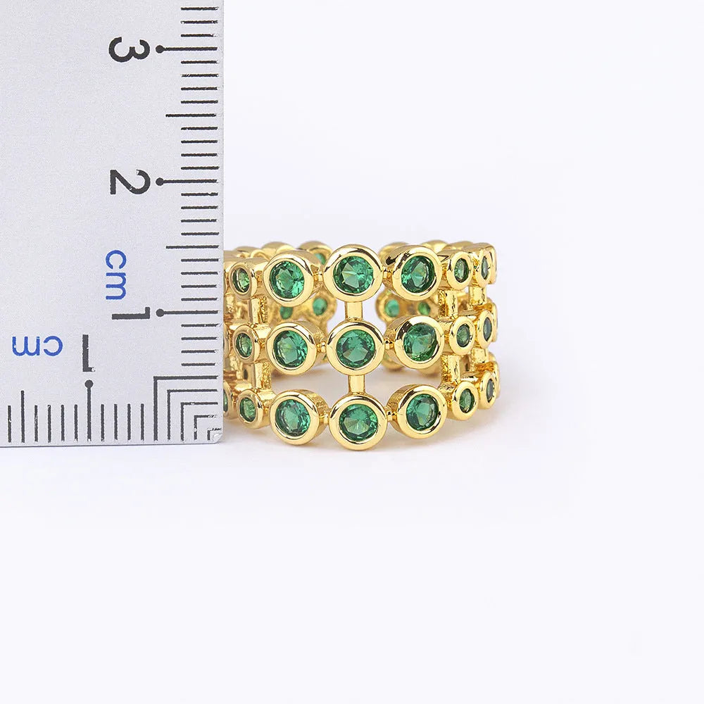 Copper wide band ring plated in 18K gold, fully set with green zircon stones.