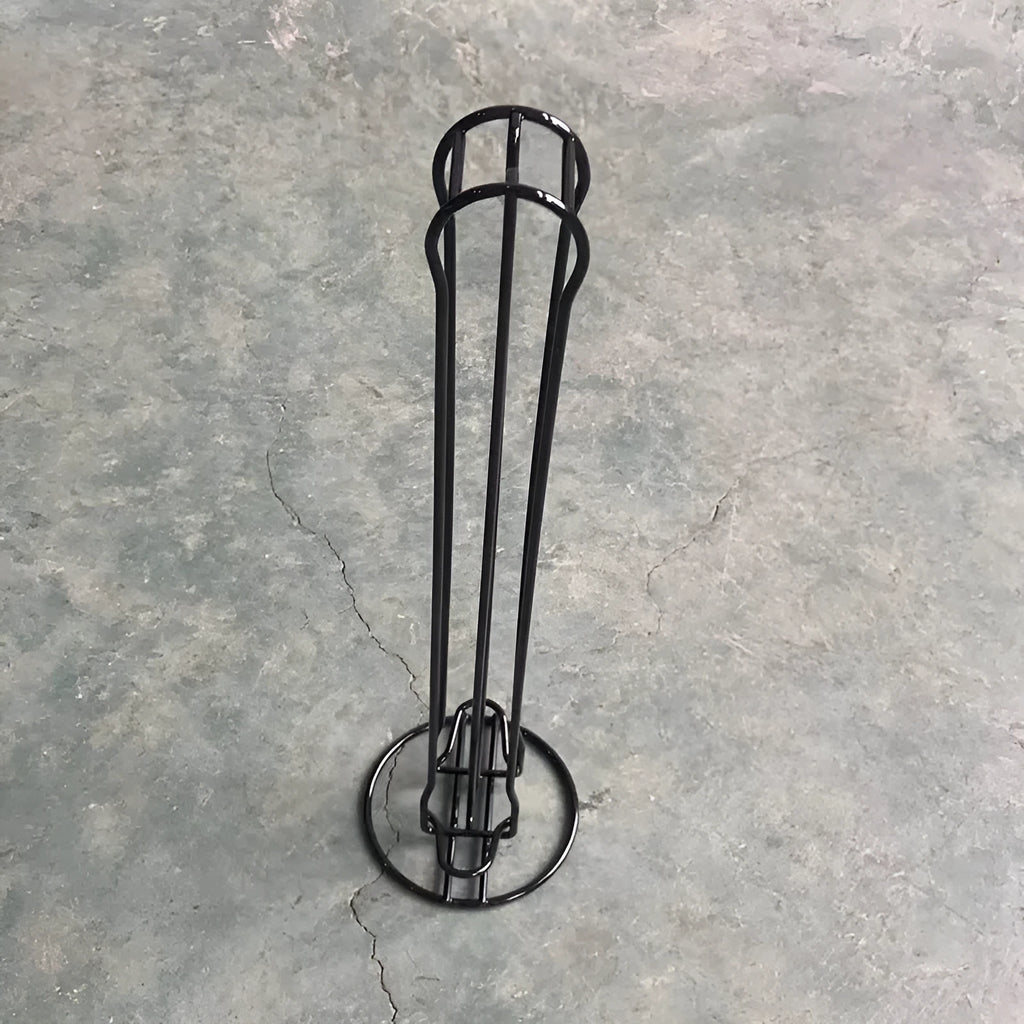 Black wrought iron coffee capsule storage rack holding coffee pods on kitchen counter