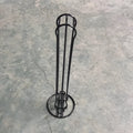 Black wrought iron coffee capsule storage rack holding coffee pods on kitchen counter