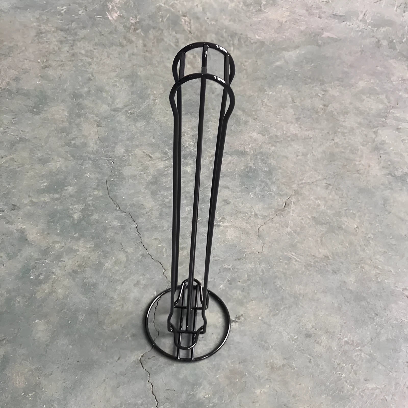 Black wrought iron coffee capsule storage rack holding coffee pods on kitchen counter