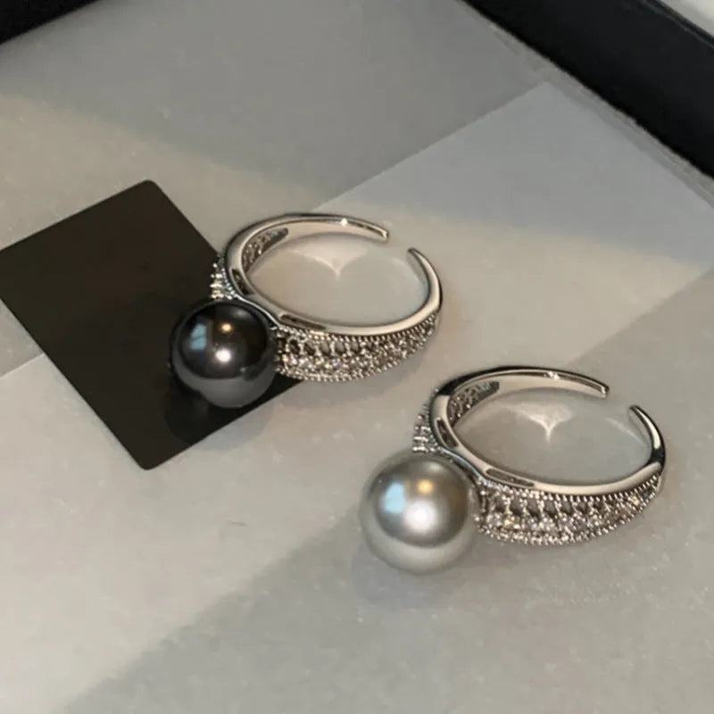 Adjustable copper geometric ring with black pearl detail on open-ended design