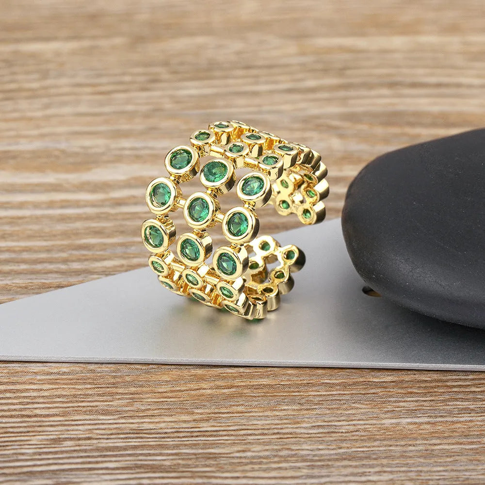 Copper wide band ring plated in 18K gold, fully set with green zircon stones.
