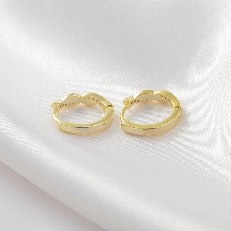 Women's geometric round earrings with interwoven hemp rope detail on a diamond-cut copper frame in gold colour.