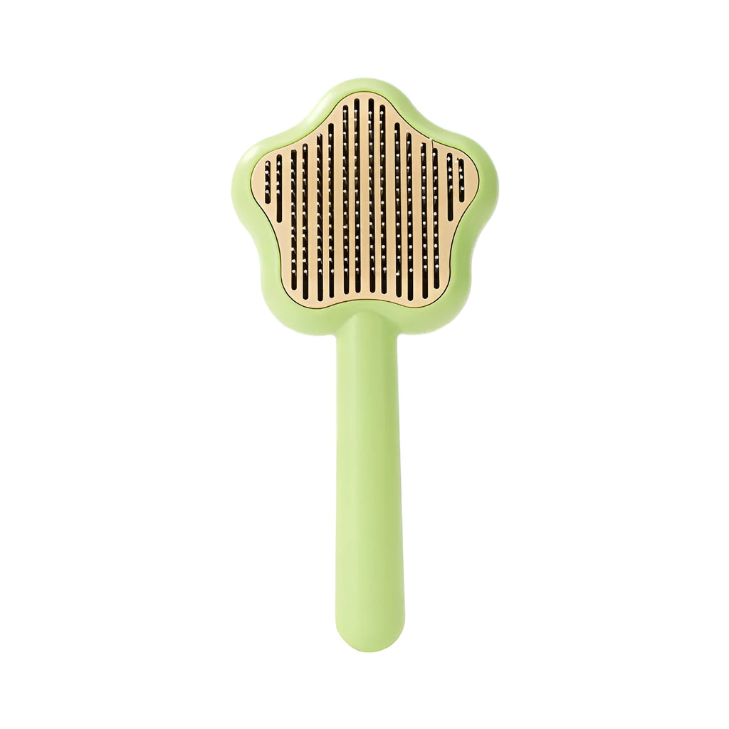 Green handled self-cleaning pet comb with stainless steel teeth on a white background.