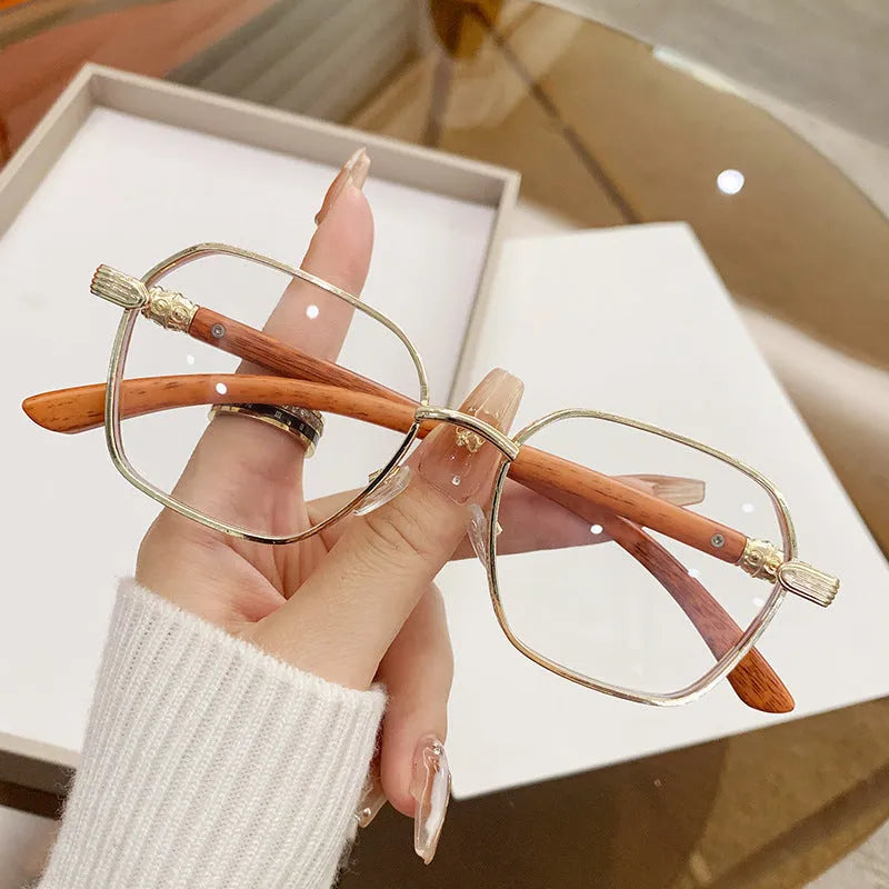 Women's gold alloy frame glasses with wood grain pattern and multiple coloured interchangeable lenses.