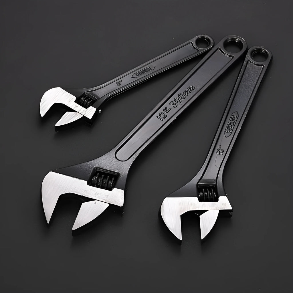 Blackened high carbon steel adjustable open-end wrench on a workbench, jaw set to mid-opening.
