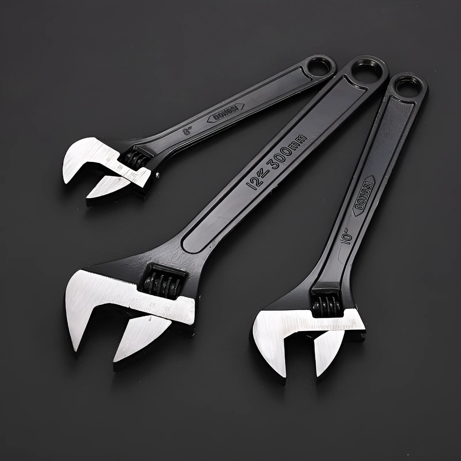 Blackened high carbon steel adjustable open-end wrench on a workbench, jaw set to mid-opening.