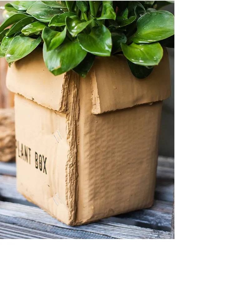 Cement flowerpot with brown paper box design and drainage holes for indoor planting