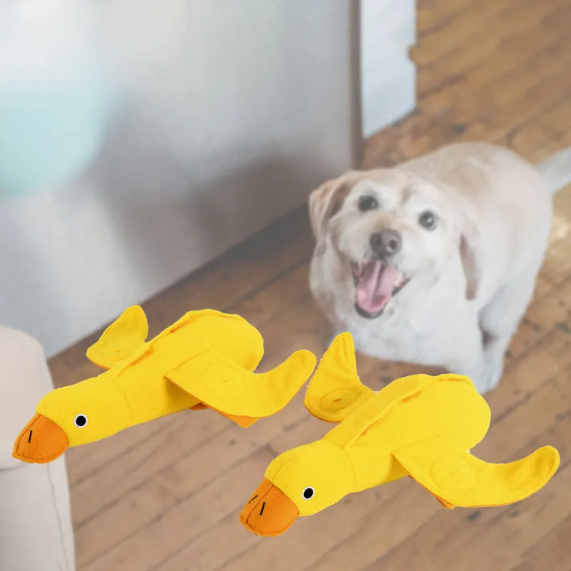 Yellow plush duck dog toy with squeaker and treat dispensing holes for training and chewing.