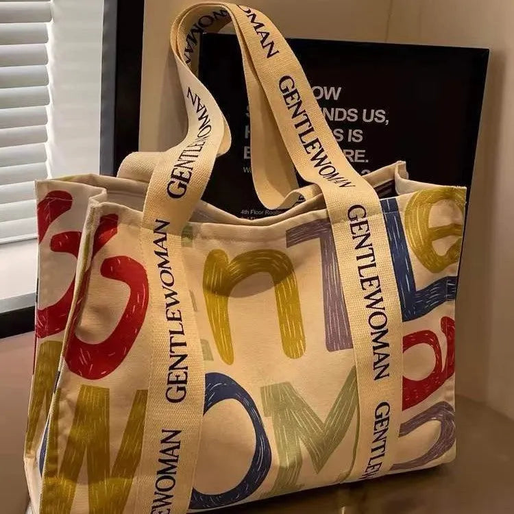 Large canvas shoulder tote bag with printed design, shown in available colour and pattern options.