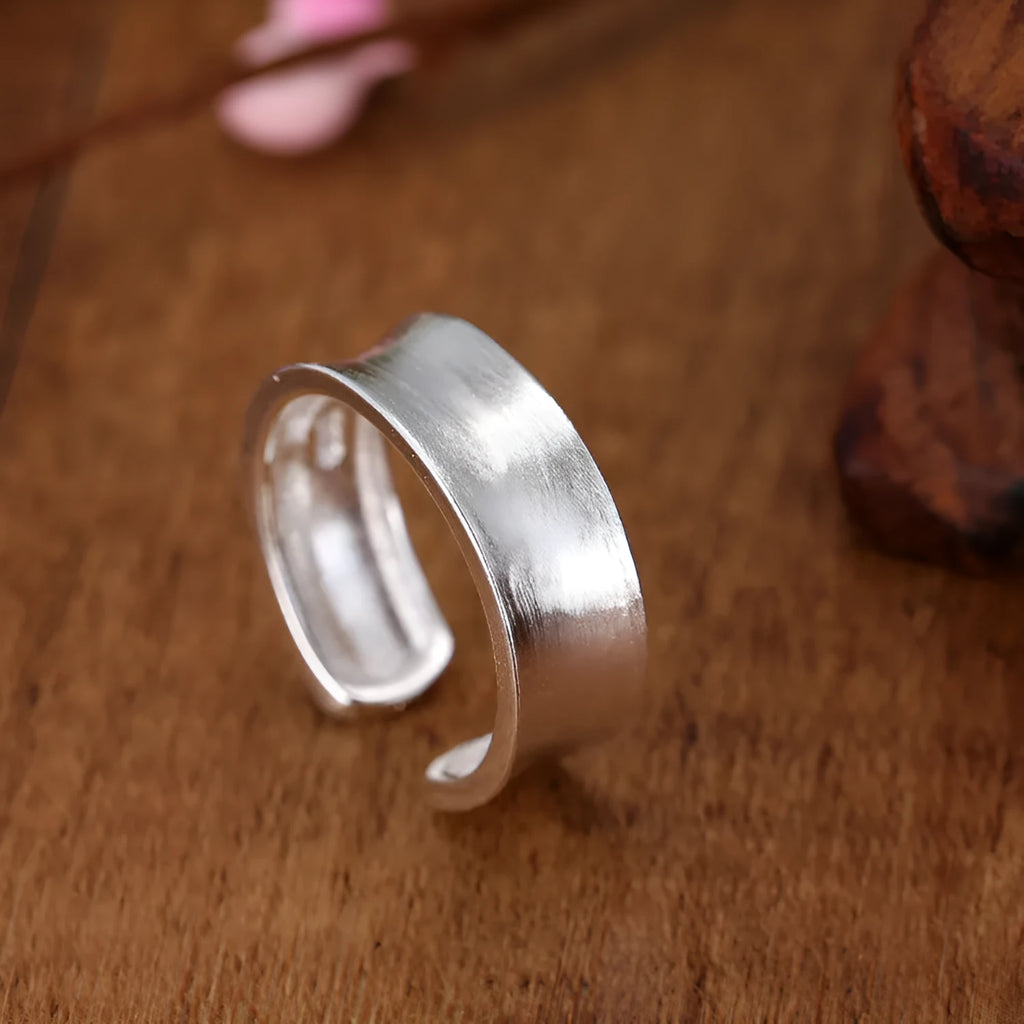 Geometric open ring in frosted sterling silver on a neutral background, showing adjustable opening.
