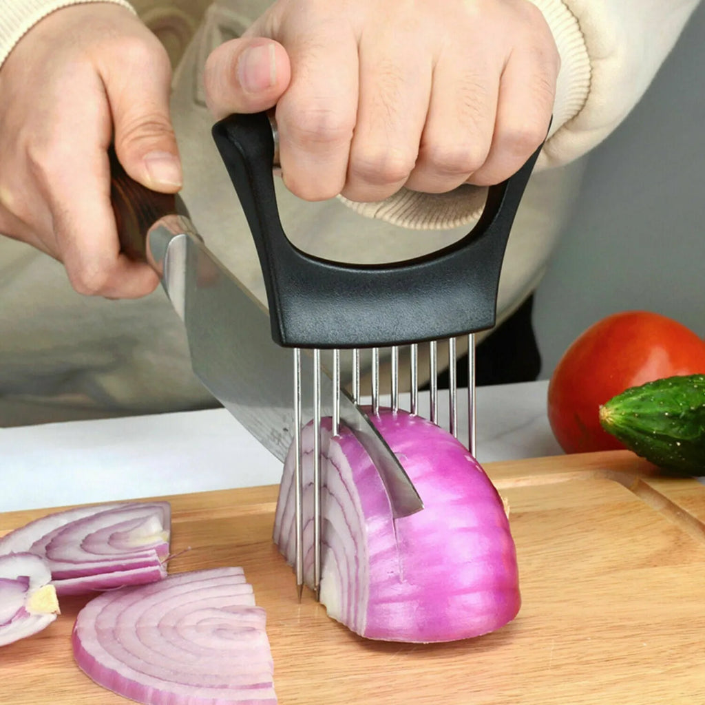 Stainless steel onion holder slicer with non-slip base on a kitchen counter, holding a tomato for slicing
