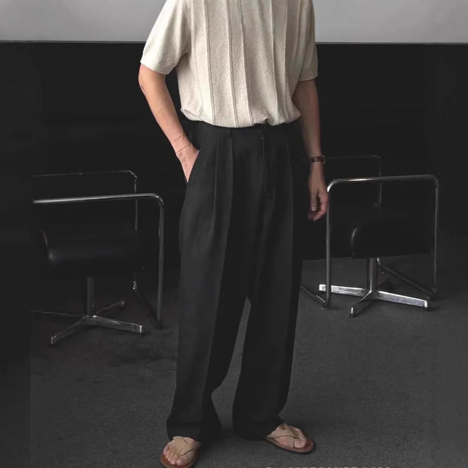 Men's lightweight apricot coloured loose-fit linen trousers laid flat, showing zip fly and relaxed leg style.