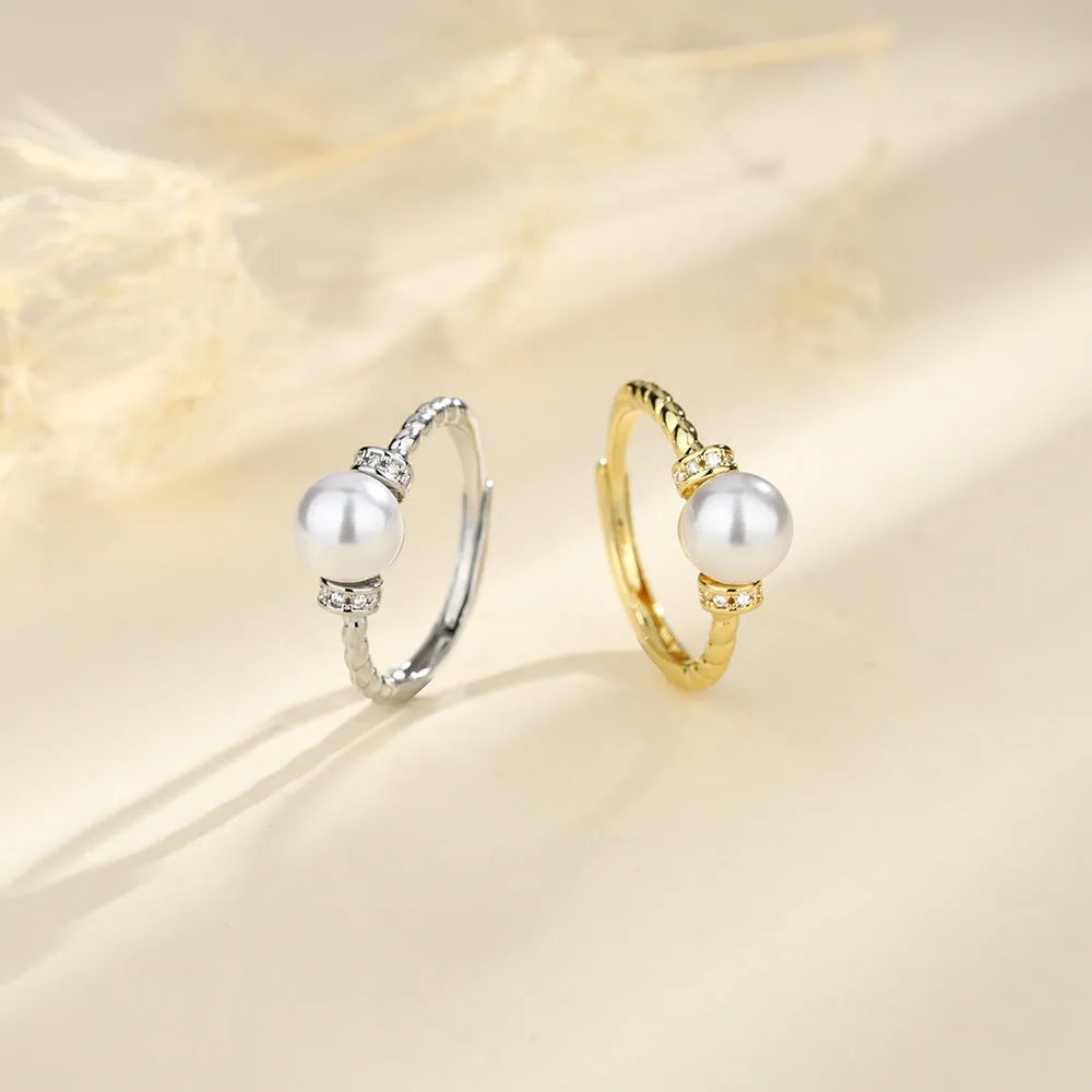 Adjustable copper ring with geometric twist design and pearl inlay in gold colour