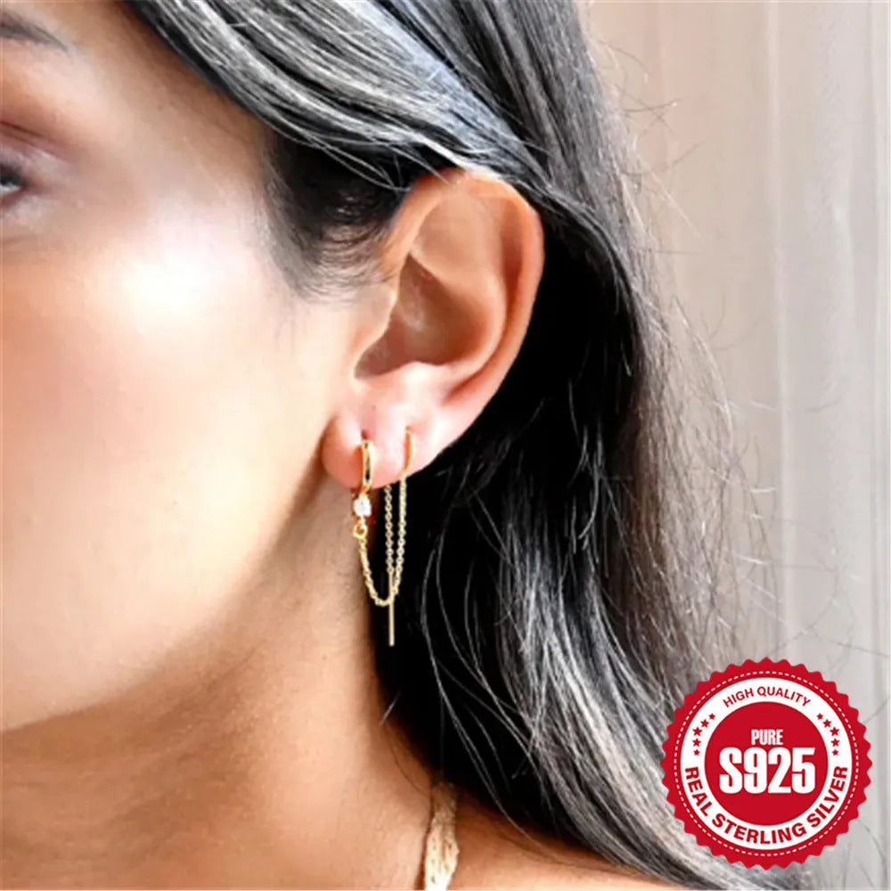 S925 sterling silver geometric drop earrings with flower, tassel, and chain details on an ear clip stud, in a golden tone.
