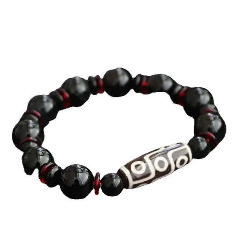 Hand-woven black agate Dzi bead bracelet with 11mm geometric beads on a wrist