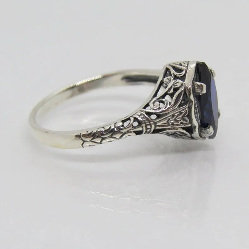 Silver alloy geometric hollow ring with zircon stone on white background, women's ring size 7
