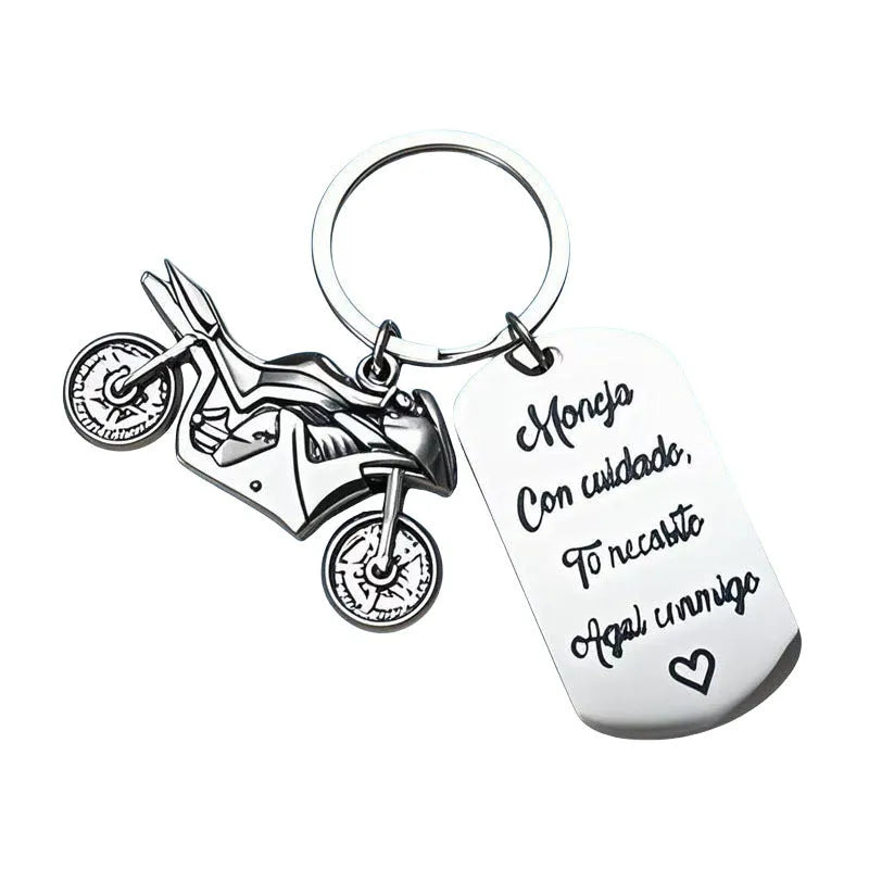 Stainless steel motorcycle-themed keychain with inspirational text alongside a flannel storage pouch.