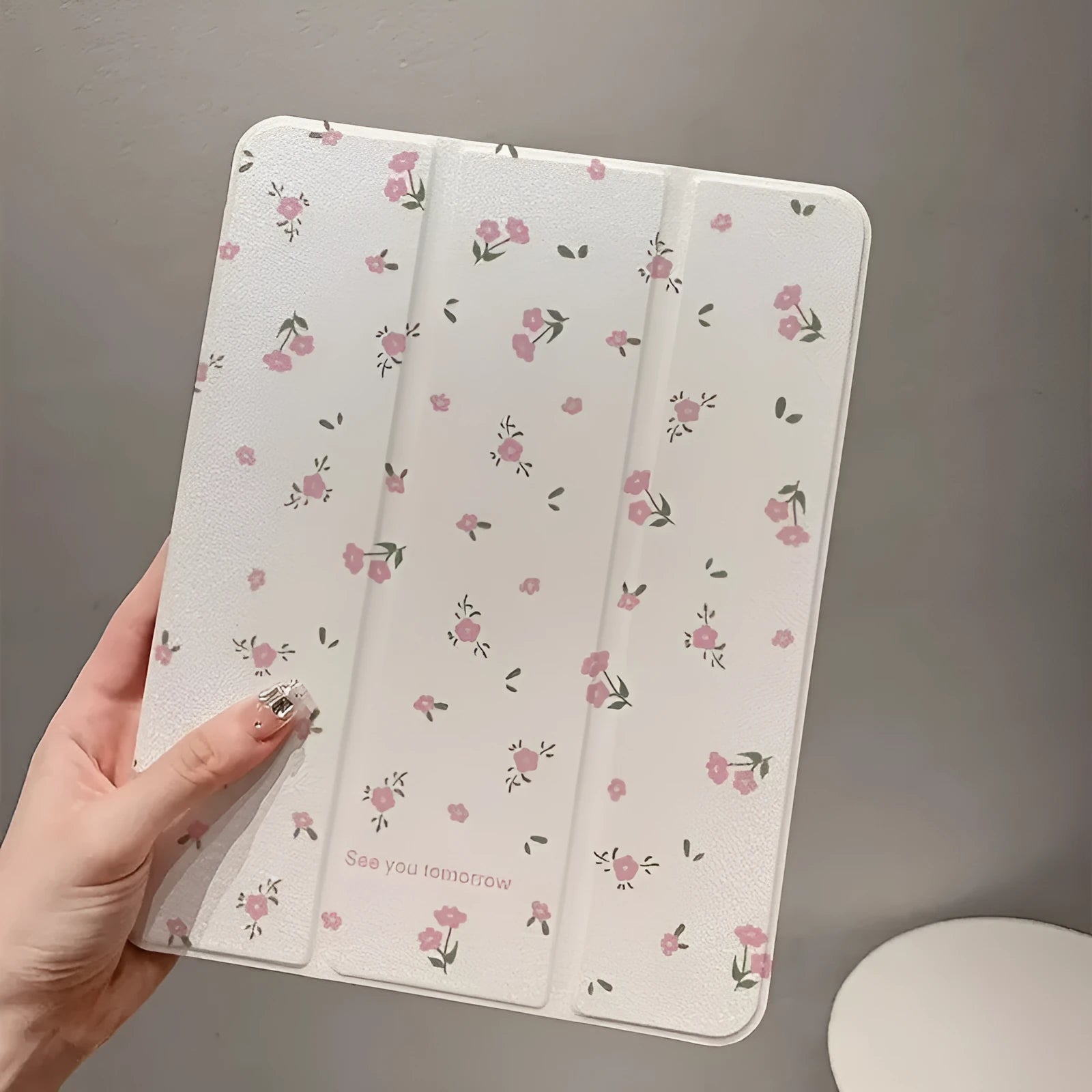 Transparent floral patterned tri-fold iPad case with magnetic stand function showing compatible tablet models