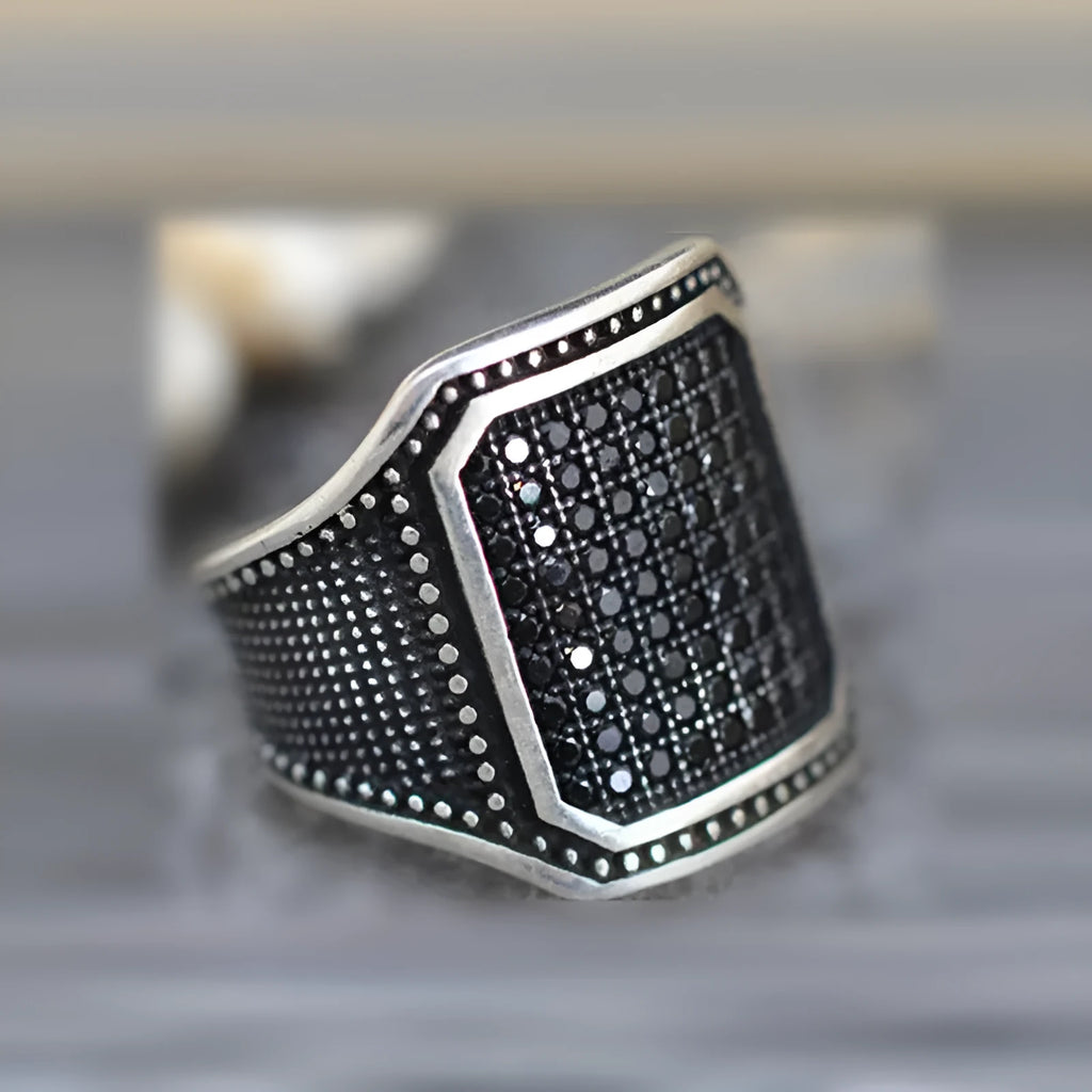 Black alloy ring with copper detailing around zircon stone on finger, showing European American jewellery style