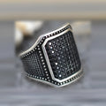 Black alloy ring with copper detailing around zircon stone on finger, showing European American jewellery style