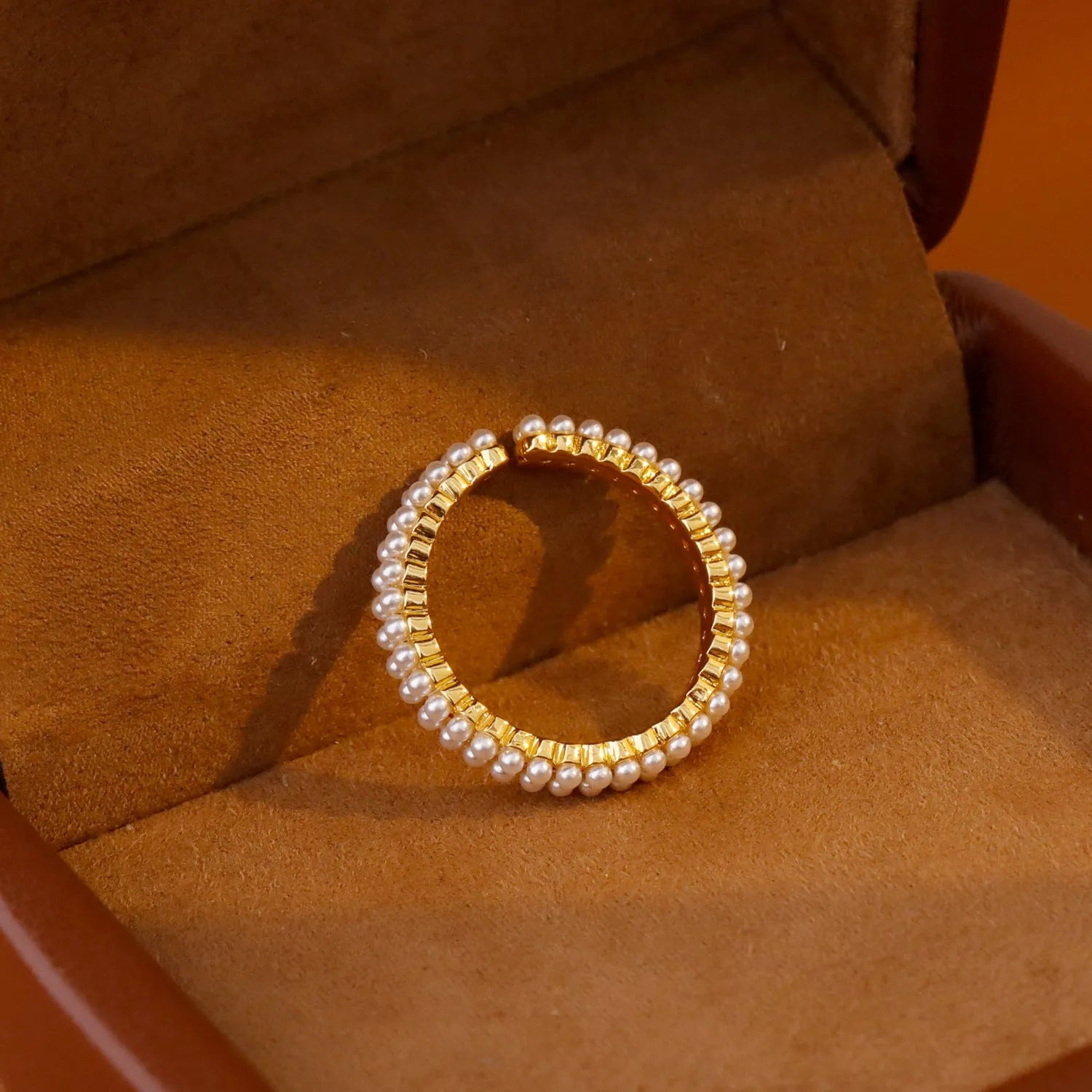 Gold geometric open mouth women's ring with round pearl design elements on copper base