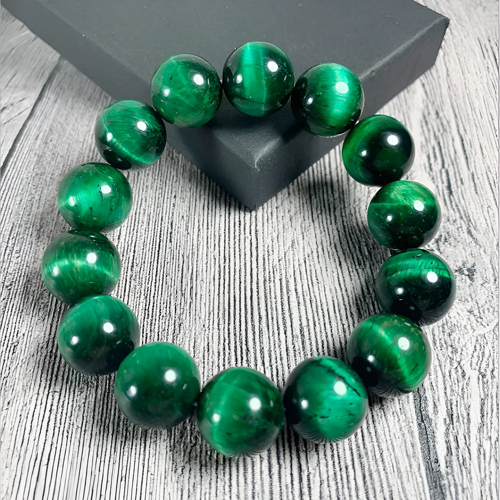 Green tiger eye stone bracelet with geometric polished beads on a wrist.