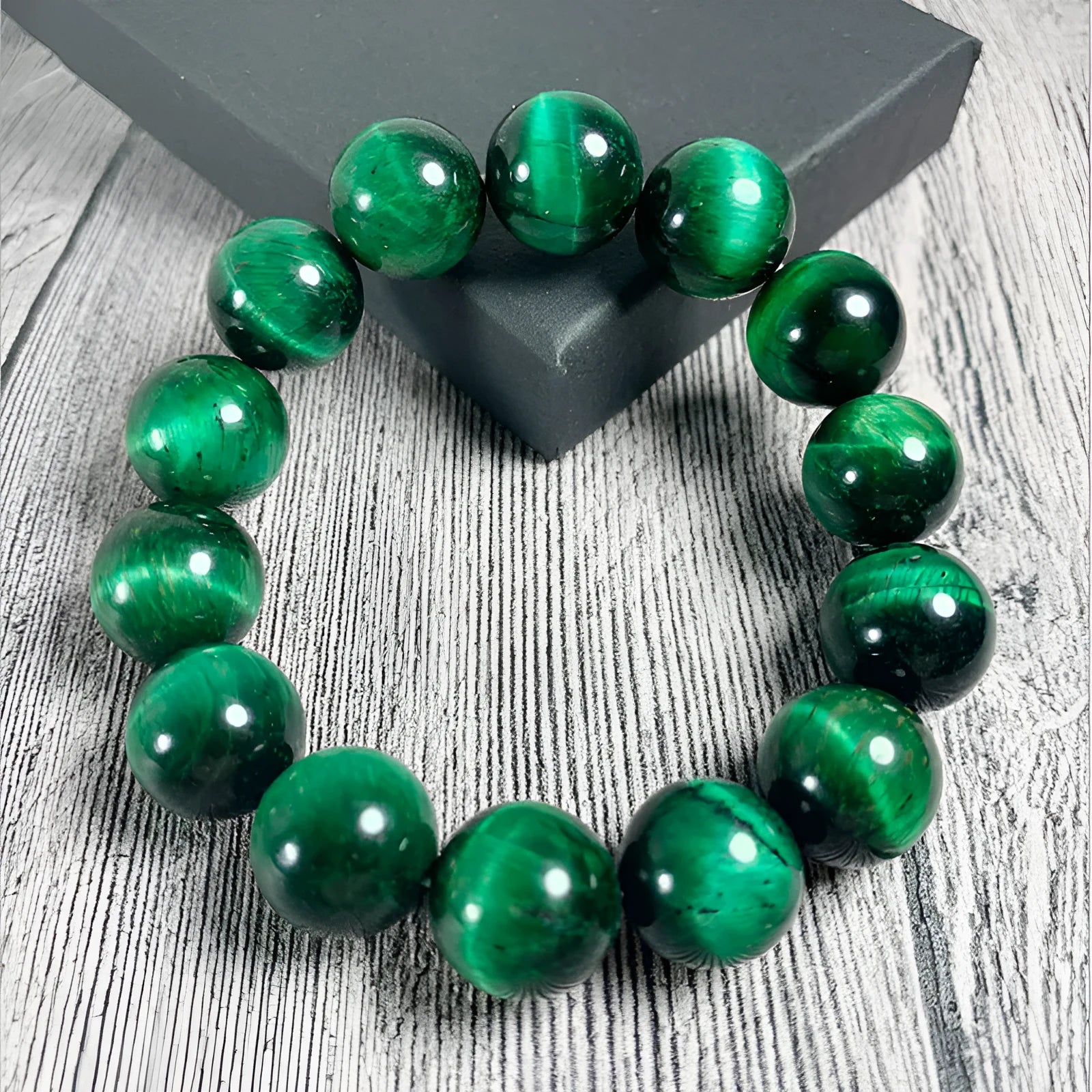 Green tiger eye stone bracelet with geometric polished beads on a wrist.