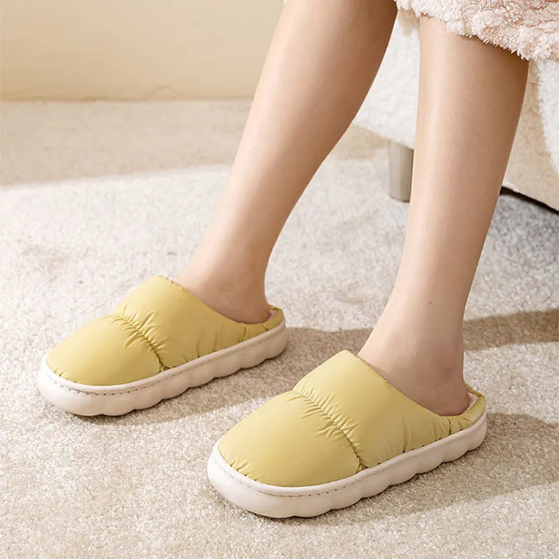 Blue winter house slippers with artificial leather upper, thick rubber sole, and plush lining on a wooden floor.