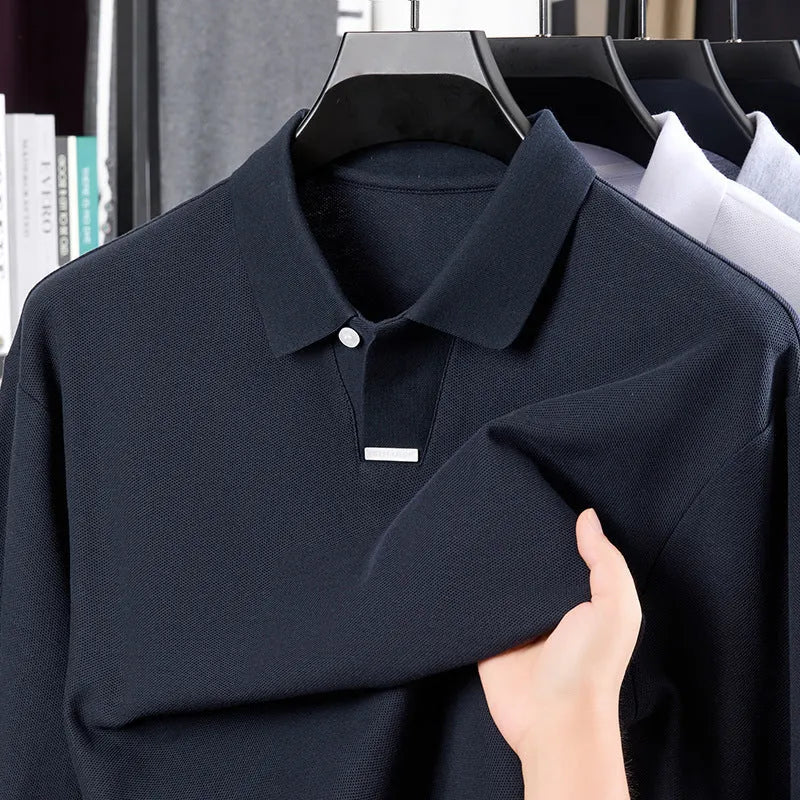 Man wearing a grey loose fit cotton polo shirt with a lapel collar and long sleeves.