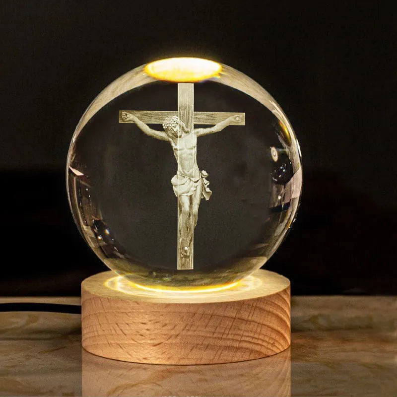 White crystal ball desk ornament with religious symbols on warm light wooden base