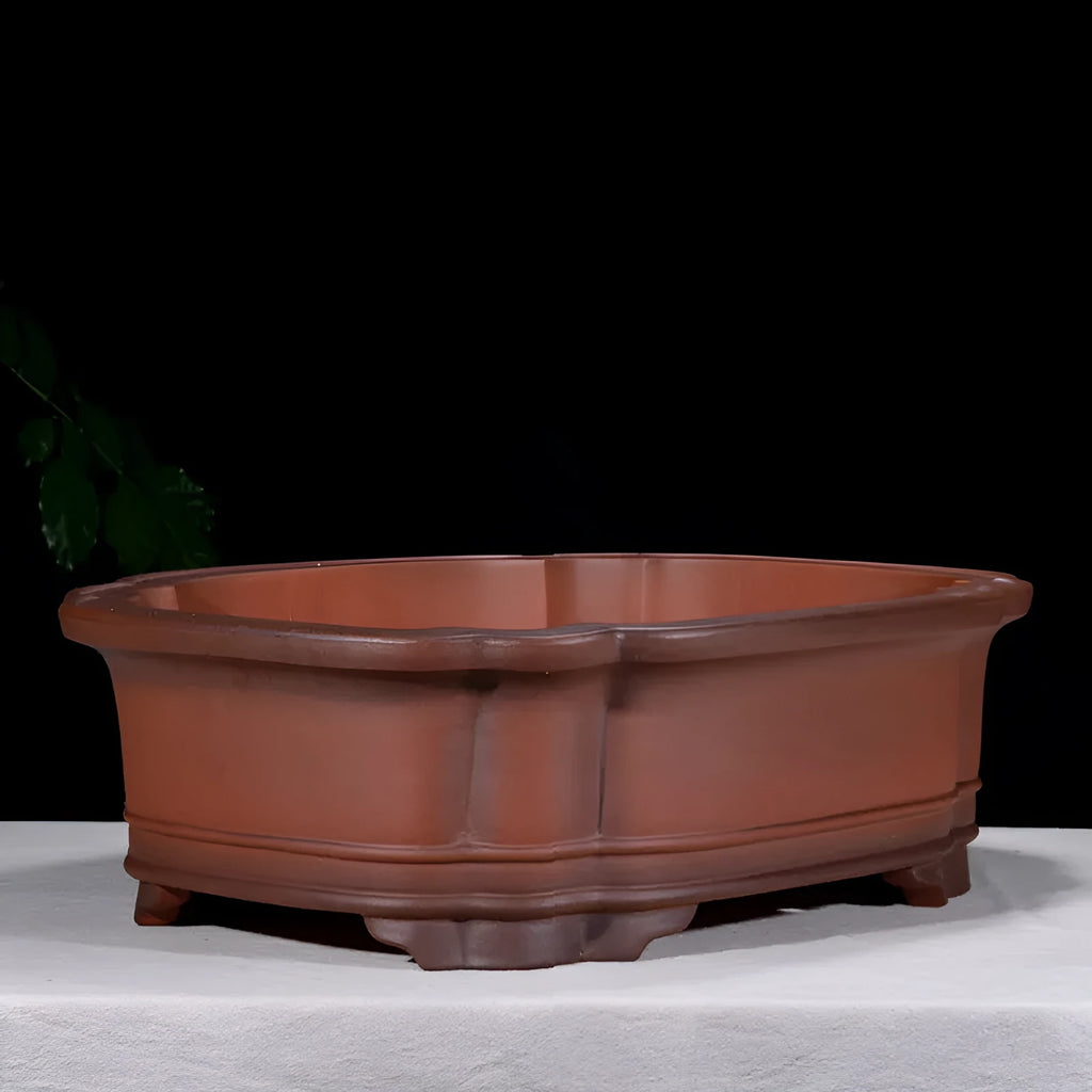 Antique-style purple clay flowerpot with Chinese decorative motifs showing tree stump, pine, cypress, pomegranate, golden marble, antique jade belt, and crabapple designs