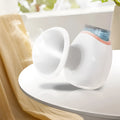 White and purple portable eye humidifier with USB charging cable on a desk