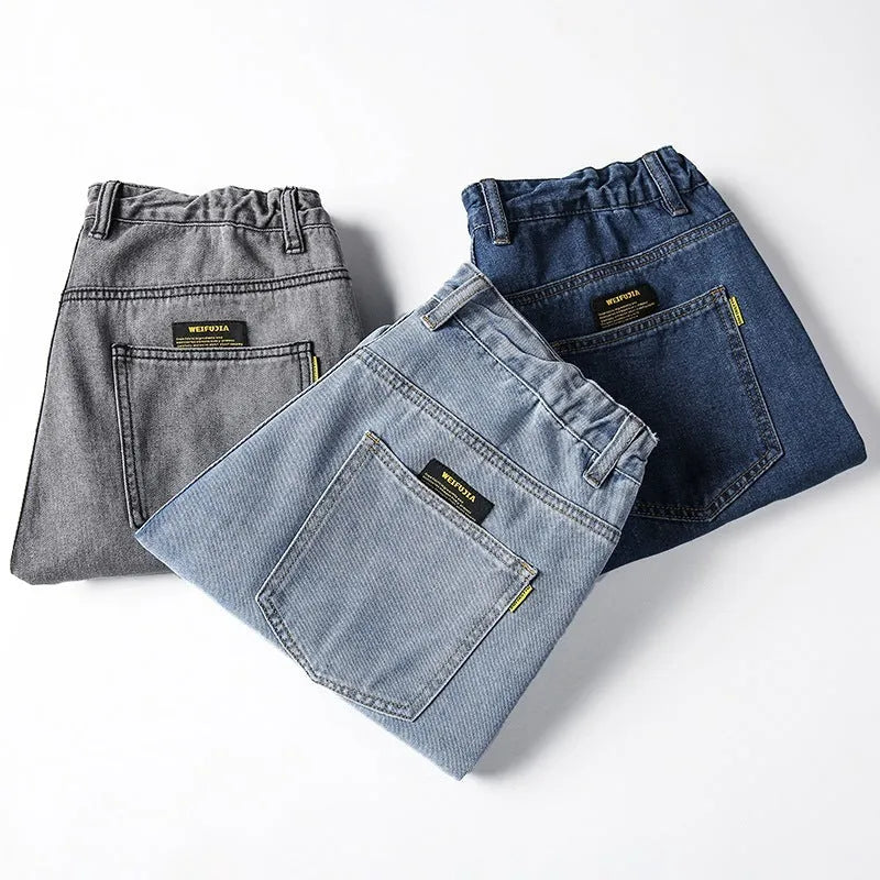Men's loose straight fit casual jeans in dark blue cotton fabric, showing mid waist and zipper fly.