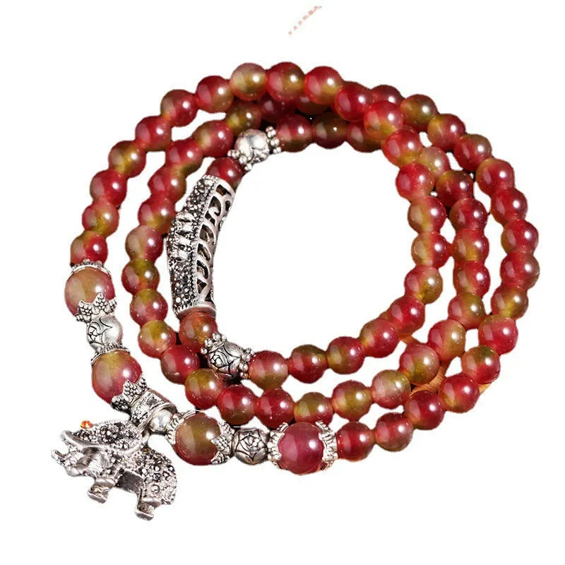 Natural watermelon crystal Chinese knot bracelet with elephant style beads.