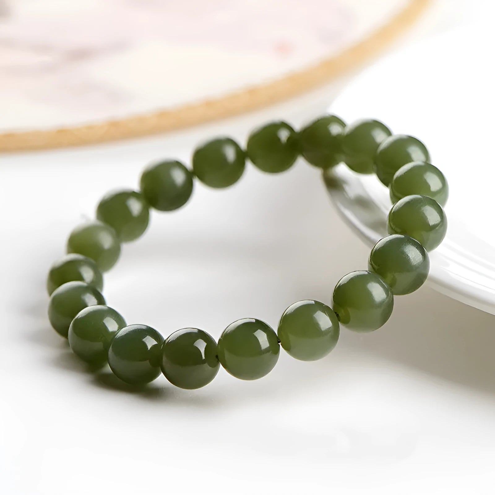 Polished Hetian jade ball bracelet with ice-like translucent beads in spherical shapes on a plain background