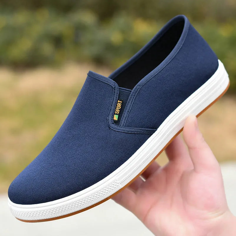 Men's low-top canvas slip-on shoes in blue colour showing round-toe design and composite soles