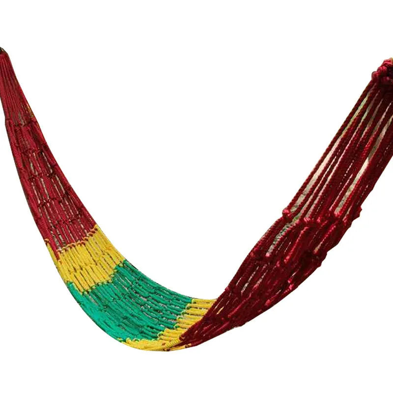 Nylon rope mesh hammock hung between two trees in a garden setting.