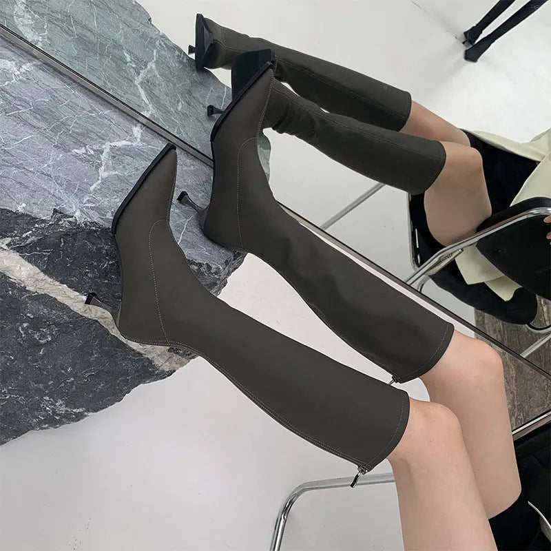 Black pointed toe women's below knee stiletto boots with a back zipper closure.