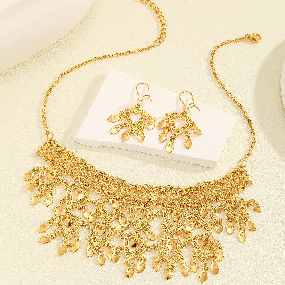 Gold alloy heart-shaped hollow necklace and matching earrings set on display with multiple hanging leaf ornaments