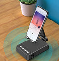 Black mobile phone broadcaster stand with Bluetooth speaker and microphone on a desk