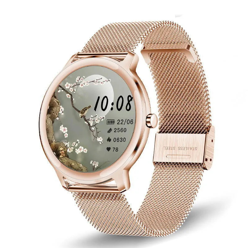 Women's silver smartwatch with stainless steel mesh band and round touch screen on a wrist.