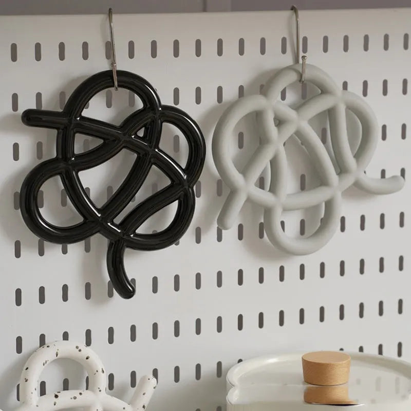 Ceramic heat proof mat in irregular shape showing bright black, coconut milk grey, and splash ink colour options
