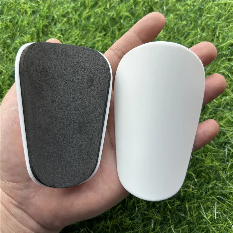 Extra small mini football shin guards measuring 8x5cm in black and white plastic