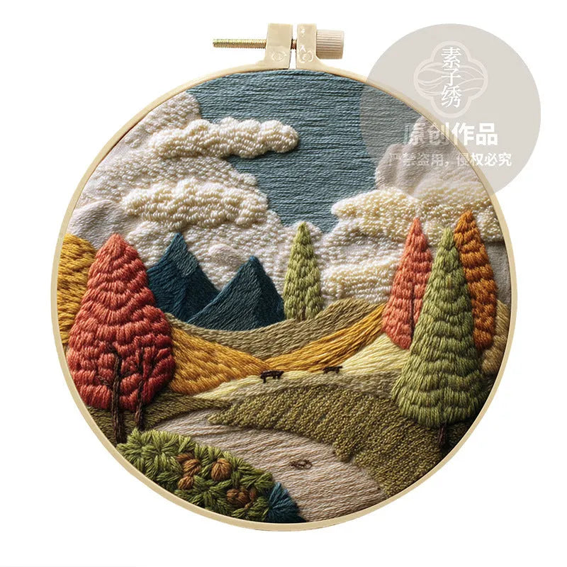 Embroidery kit with printed landscape design fabric, coloured thread, needles, and bamboo frame