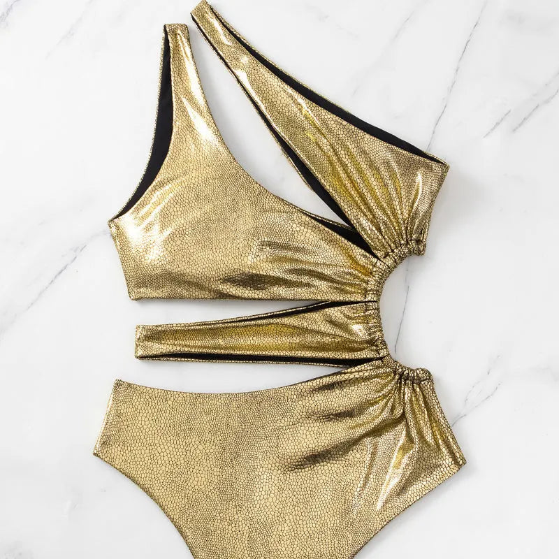 Women's gold backless one-piece swimsuit made from Spandex, shown on a mannequin.