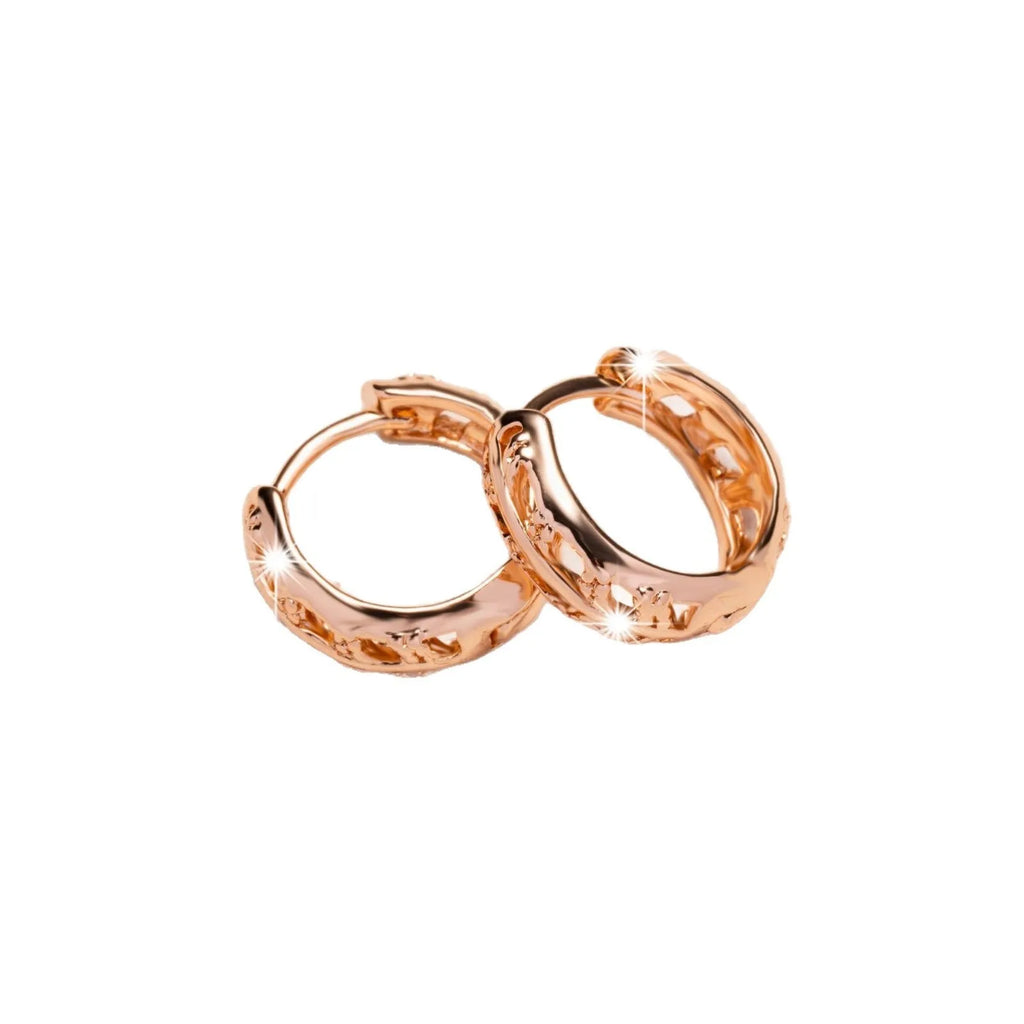 A pair of rose gold hollowed earrings with intricate leaf and heart shapes.