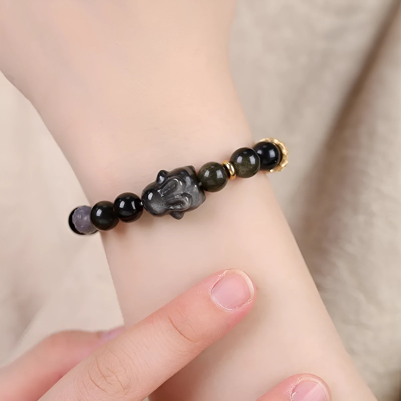 Handmade national style bracelet with lying rabbit Jin Yaoshi charm on neutral background, 8mm beads